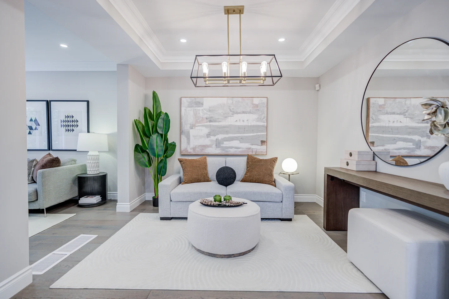 Staged seating area with a sofa, round coffee table and overhead light fixture at 30 Elmeade Lane